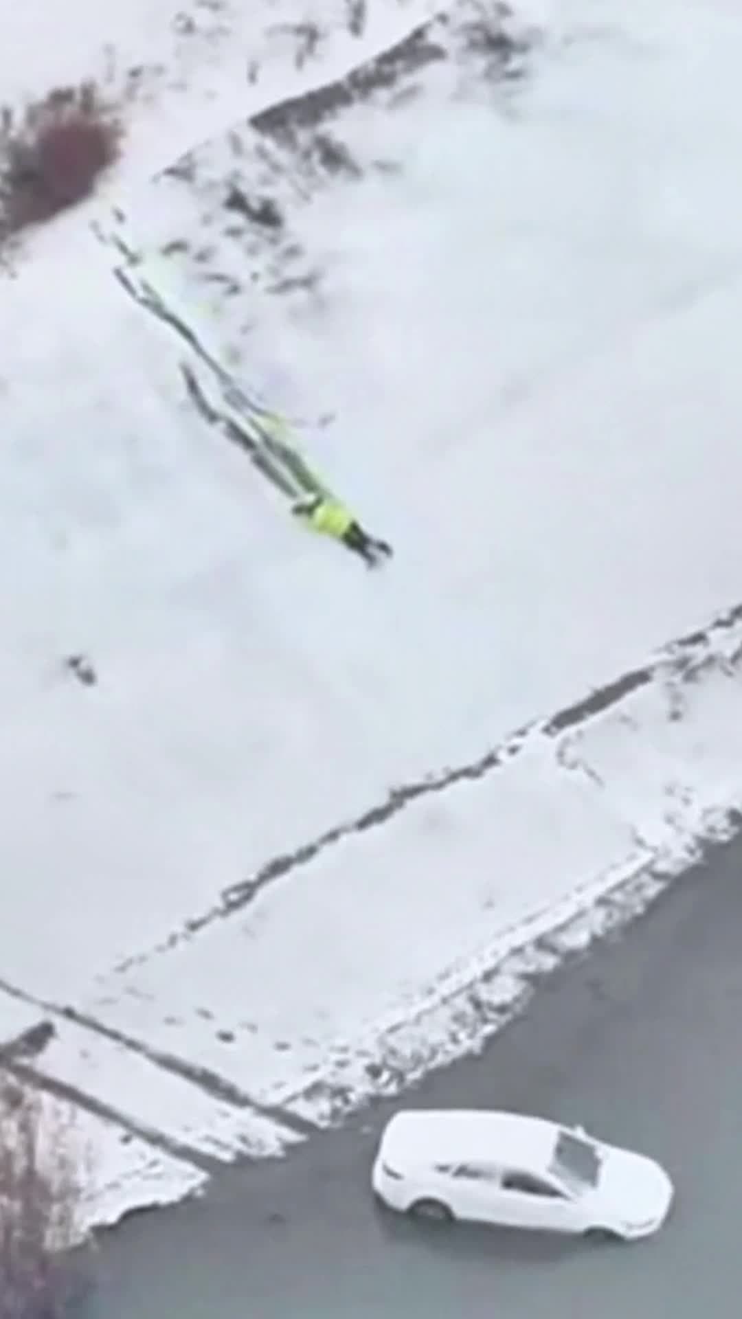 ตำรวจจราจรจีน' ใจกล้า ไถลตัวบนหิมะริมฝั่ง รุดช่วยรถตกแม่น้ำ